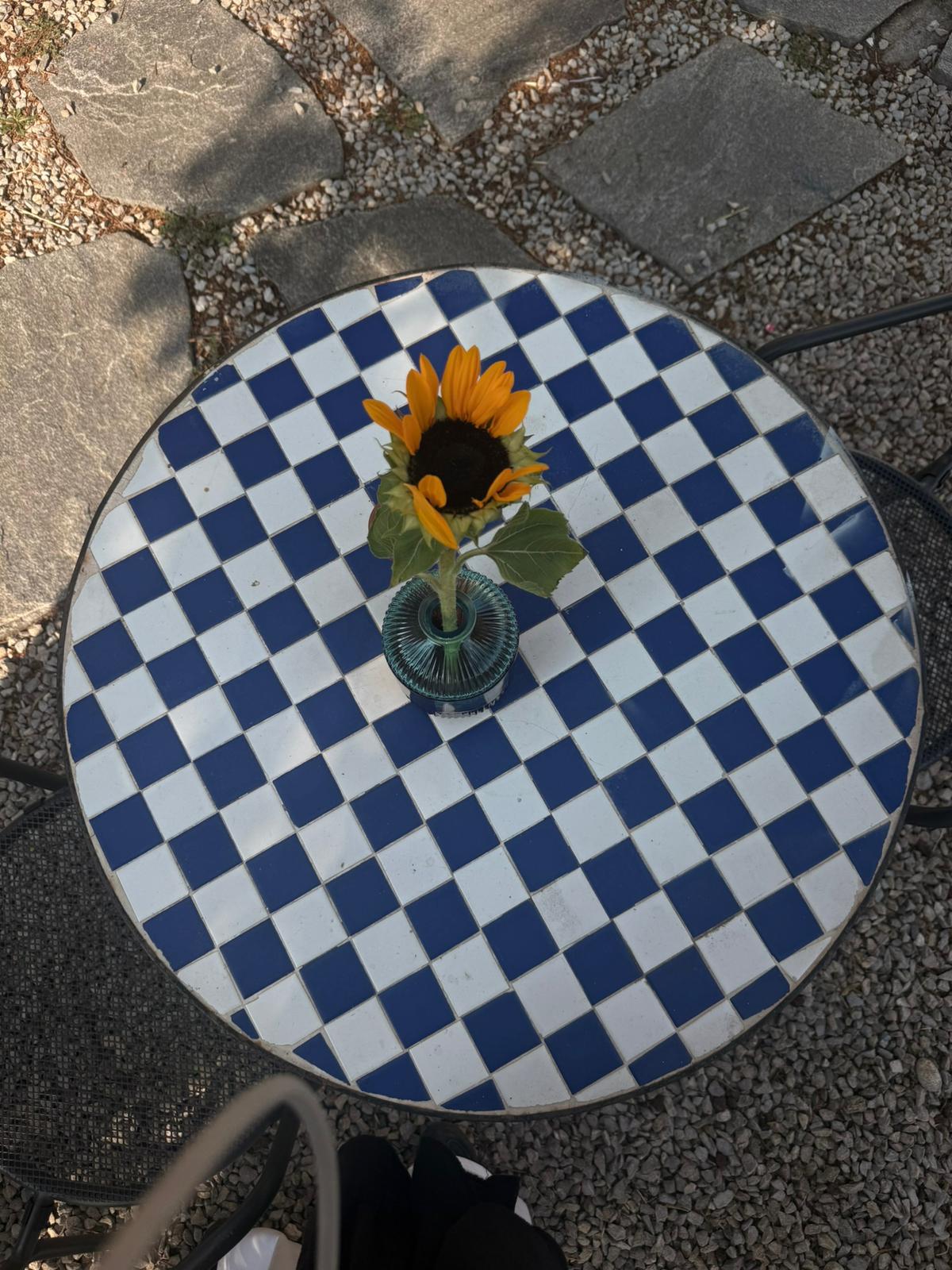 Tavolino a scacchi blu e bianchi con un girasole al centro